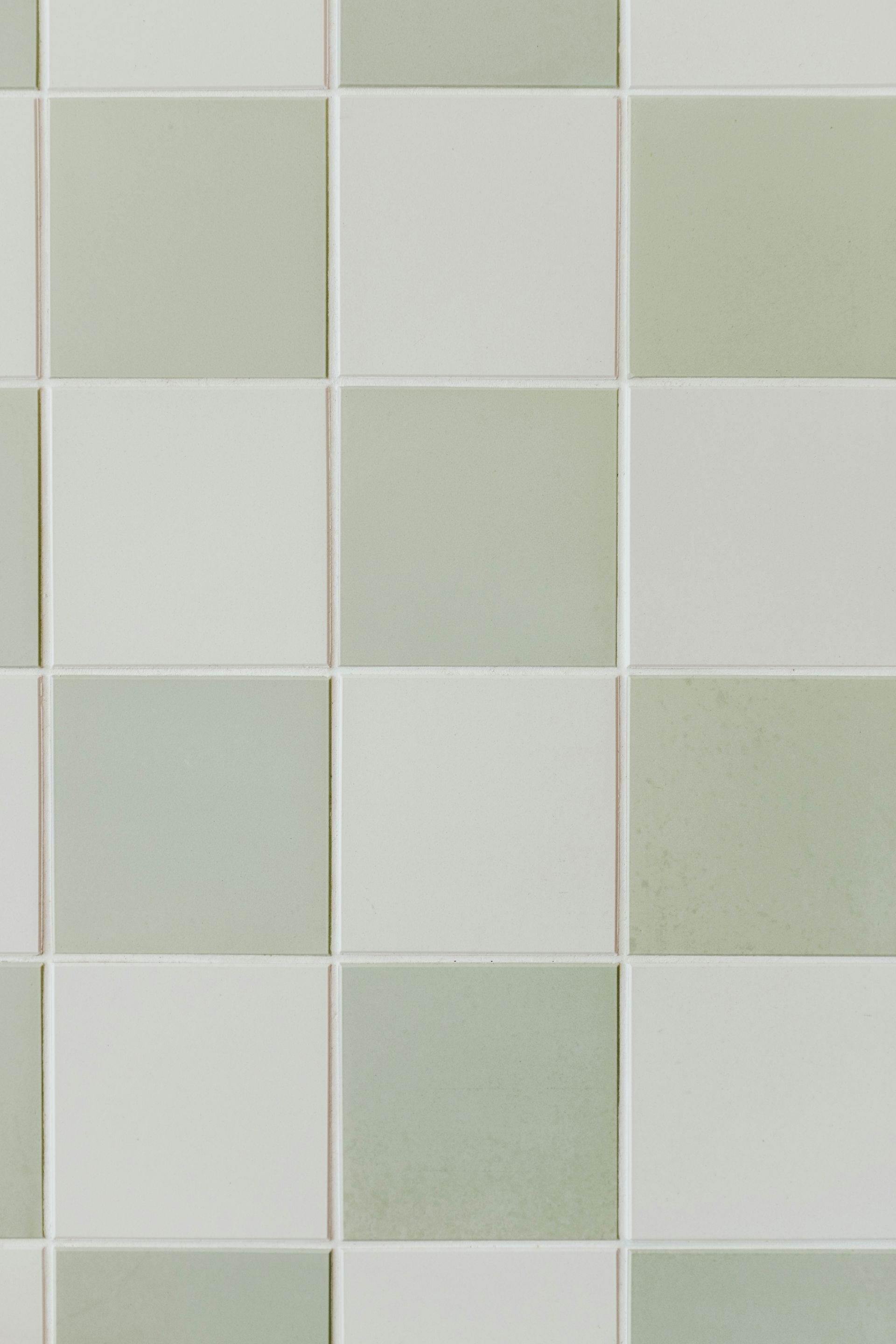 A grid of alternating sage green and off-white square ceramic tiles